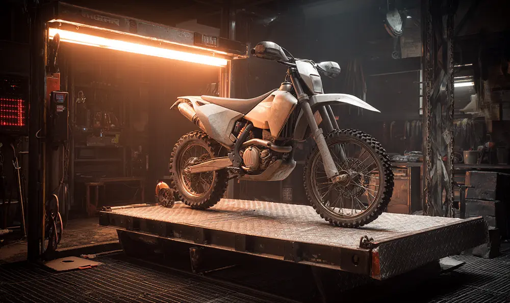 Atelier mécanique moto : lève‑moto hydraulique surélevant une moto enduro
