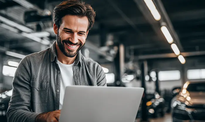 Conducteur consultant un site web de vente de pneus avec un garage en arrière-plan