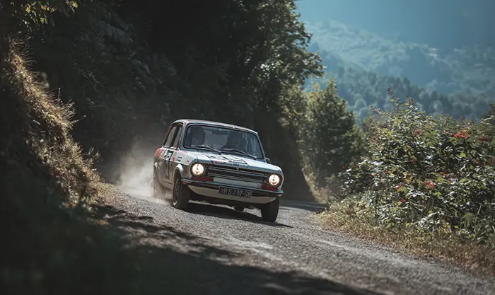 Peugeot 104 ZS2 sur route sinueuse ambiance rallye