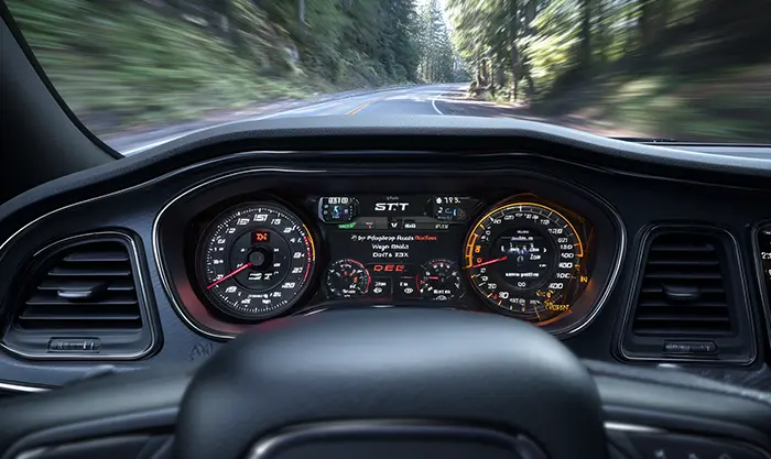 Vue intérieure du cockpit d’une Dodge Challenger SRT, volant avec palettes, tableau de bord sportif