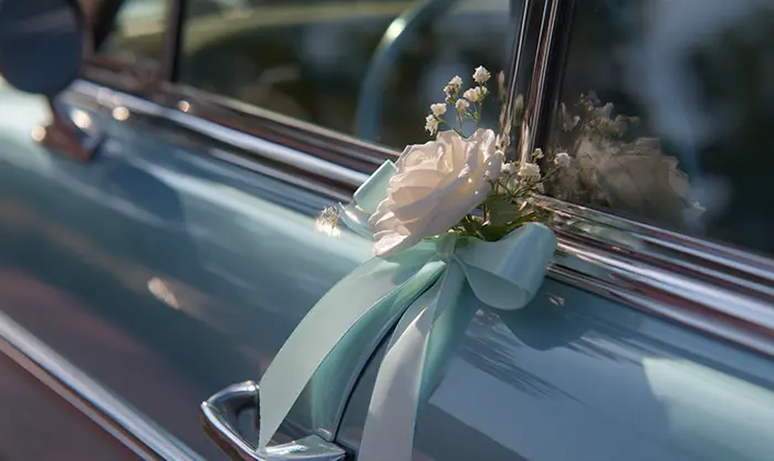 Ventouse florale et ruban pastel fixés sur carrosserie propre