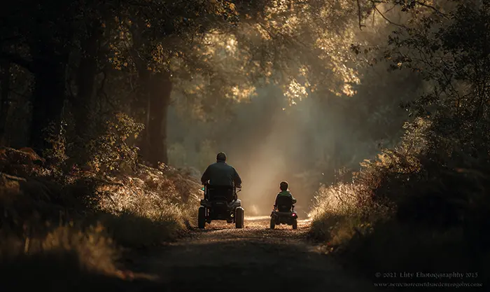 Parent et enfant roulant en buggy électrique sur sentier
