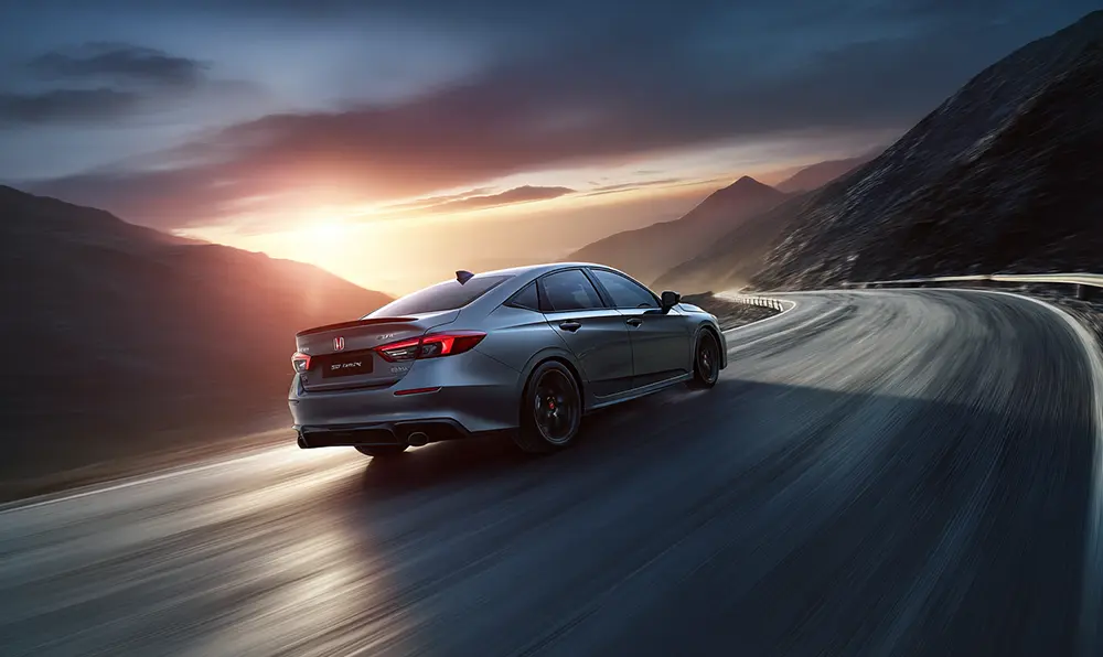 silhouette arrière de voiture avec spoiler sur route panoramique